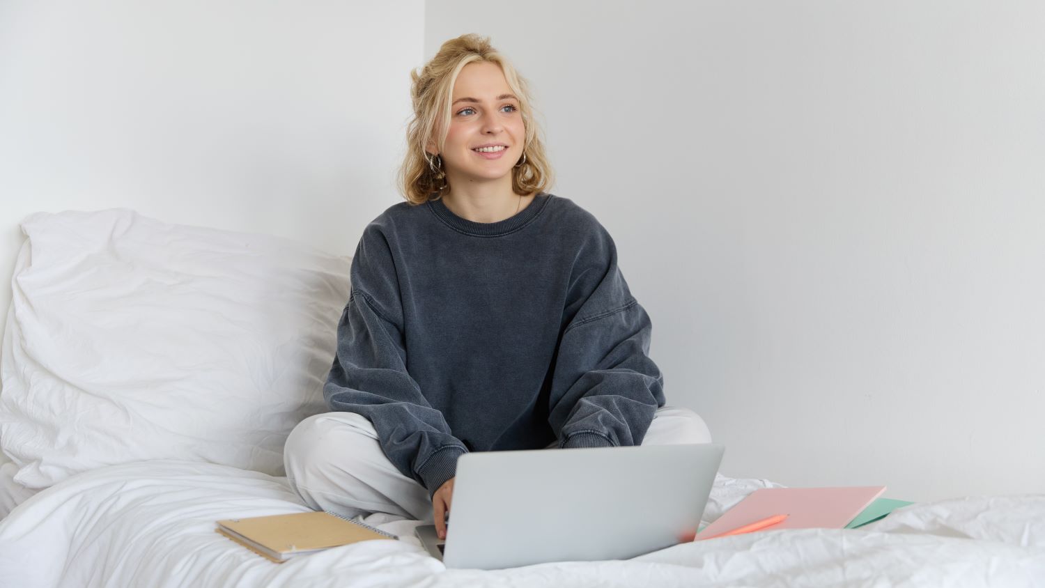Etudiante dans sa chambre assise sur son lit